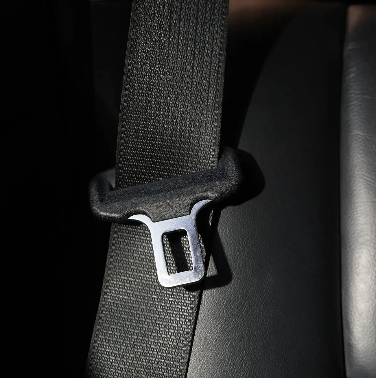 Moulded pillar loop guiding seat belt webbing with a metal tongue plate resting alongside it