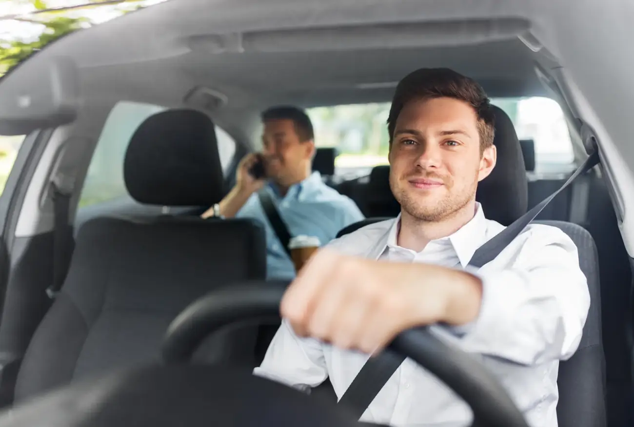 Driver and passenger belted in a vehicle cabin during a working journey
